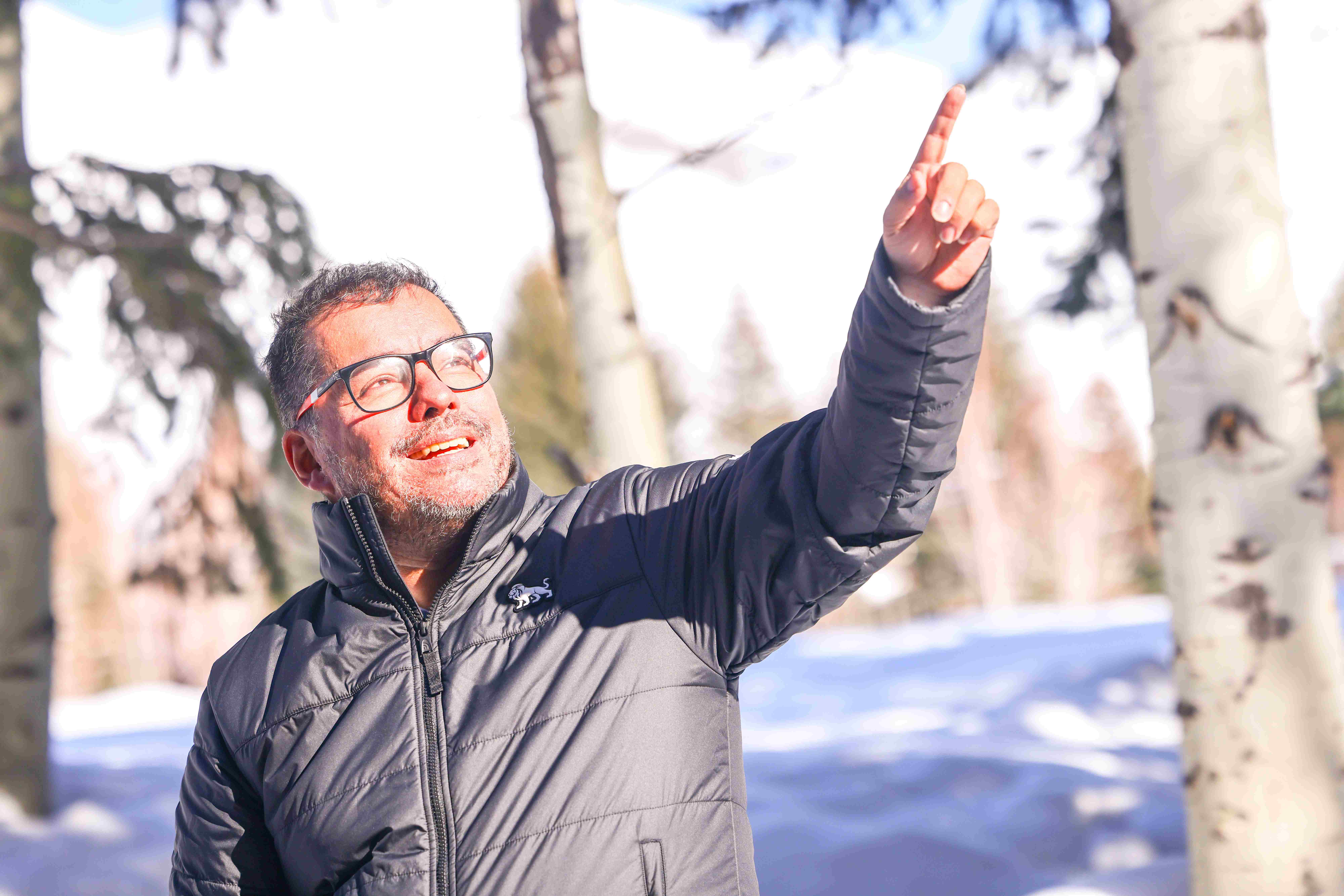 Leonardo Ramirez pointing upward in a snowy landscape